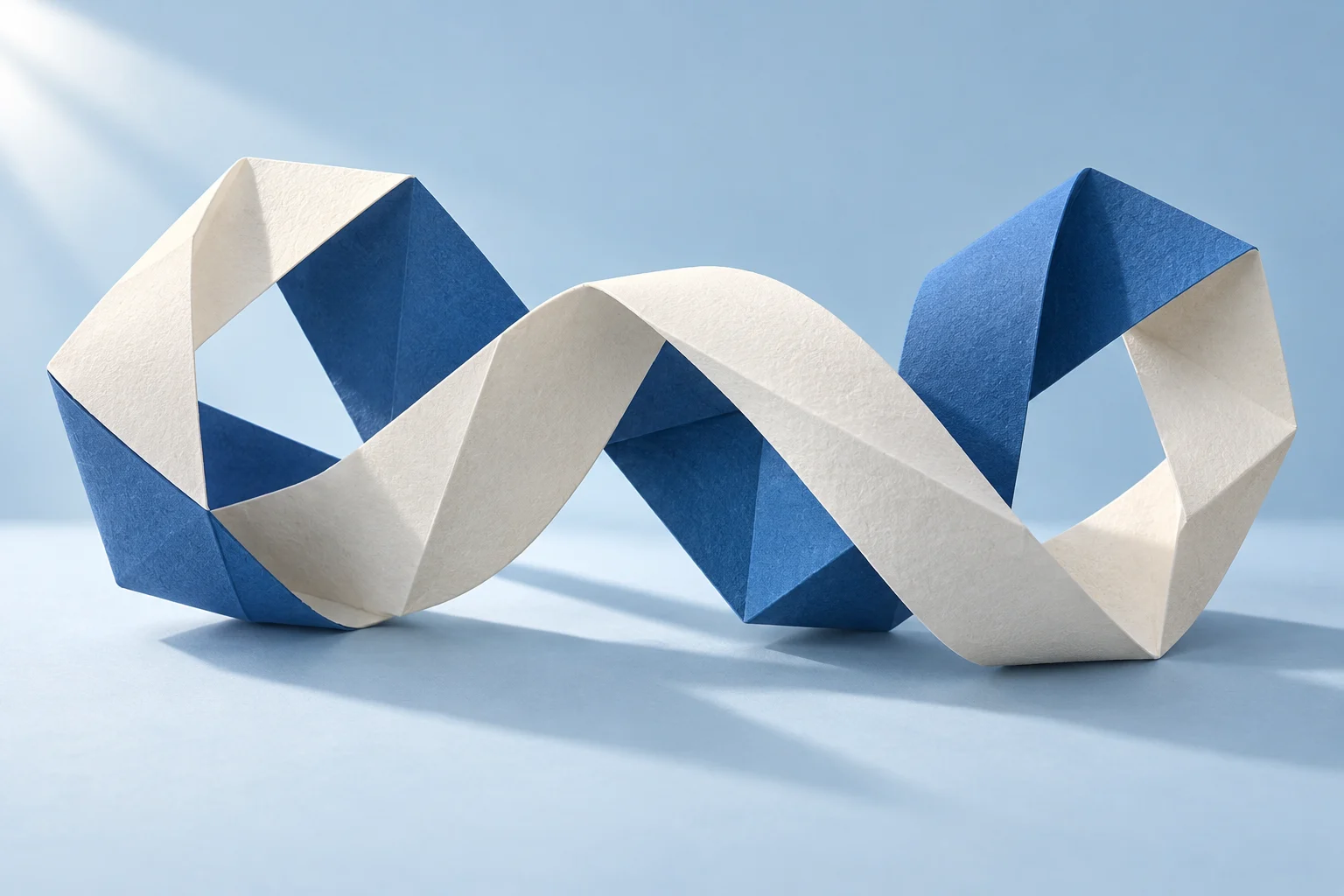 Two folded paper ribbons, one blue and one white, woven into a shared shape